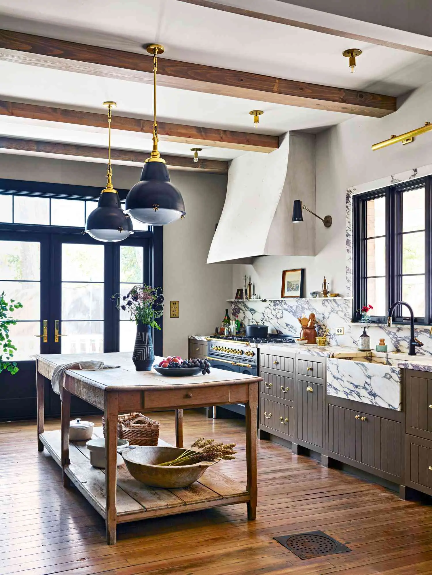 Remodeled kitchen with exposed beams, marble counters, and a farmhouse sink